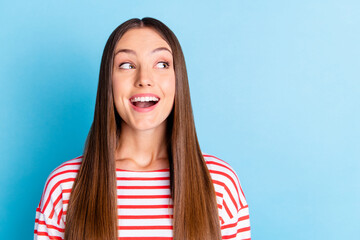 Poster - Photo of adorable excited young girl wear striped shirt looking empty space isolated blue color background