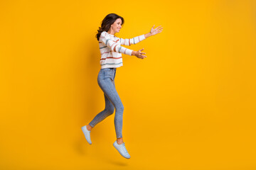 Full size profile side photo of happy excited smiling girl jumping open hands hug embrace isolated on yellow color background