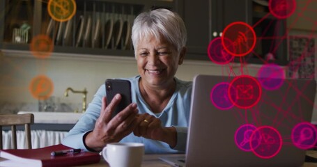 Sticker - Globe of digital icons against african american using smartphone and laptop at home