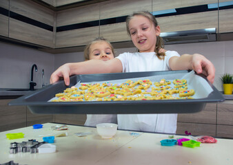 Wall Mural - Two sisters are making homemade cookies in the kitchen.