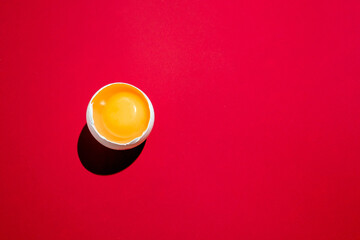 yellow egg yolk on red paper background. food concept