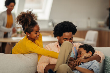 Wall Mural - Afro children is having fun with their father in the cozy of their living room