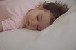 © Nutlegal - Adorable cute child sleeping on bed at night with sweet dream in bedroom Lovely toddler child get deep sleep and get relax and happy during lay down on bed Little toddler girl get good sleep