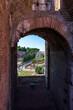 Vista del foro romano y palatino desde el coliseo, a través de uno de los arcos. Turistas paseando