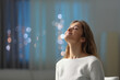 © PheelingsMedia - Satisfied tenant breathing fresh air in the night at home