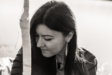 Grayscale shot of a caucasian female with a lake in the background