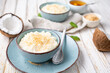 Sweet and creamy coconut rice pudding with honey, topped with grated and toasted coconut