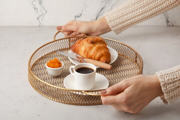 Wall Mural - Woman holding metal tray with tasty breakfast on light background