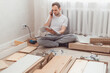 © vladdeep - Man customer calls to help center at home during assembling new furniture, calling for a master.