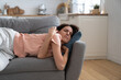 Young woman with closed eyes lying on pillow, resting, trying to sleep in uncomfortable pose on sofa at home, feel fatigue. Tired girl fall asleep, taking nap. 