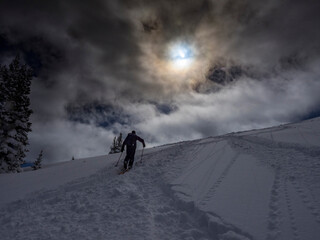 Canvas Print - Silhouetted skier climbing for powder, bluebird day in Mountains near Park City, Utah, USA.