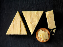 Still Life With Cheese Cracker And Cheddar Cheese Triangles On Black Slate, Overhead View