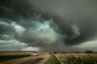 © Connect Images - Monster supercell with developing wall cloud moves across central Kansas and later forms a destructive, EF-3 rated tornado destroyed property. Storm chasers observing  storm on dirt road, USA