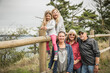 © Connect Images - Girls sitting on fence with mother and grandparents, Port Townsend, Washington, California, USA