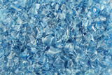 Fototapeta Tulipany - A heap of small pieces of chopped blue plastic bottles. View from above. Closeup