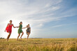 © Connect Images - Girlfriends skipping on field, Eastbourne, East Sussex, United Kingdom