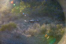 Drone (unmanned Aerial Vehicle) Flying Mid Air Over Arid Landscape