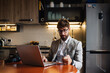 © Connect Images - Mid adult man sitting at kitchen table with laptop and credit card
