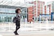 © Connect Images - Cool young woman with afro hair on city concourse, full length