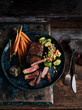 © Connect Images - Rustic low key still life with plate of rubbed steak and spiced brussels sprouts on table, overhead view
