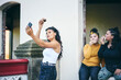 © Connect Images - Young woman taking selfie with teenage sisters while eating cakes in doorway