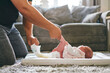 © Connect Images - Father changing baby's diaper at home