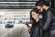 © Connect Images - Couple using smartphone outside station