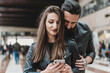 © Connect Images - Couple using smartphone in station