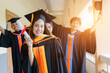 © EduLife Photos - The Asian university graduates in graduation gown and a mortarboard cap with a degree certificate in hand celebrating education achievement in the commencement ceremony. Congratulations to graduations