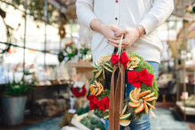 Woman Holding Christmas Wreath Inside Shop