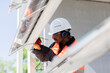 © Connect Images - Male engineer wearing hardhat and ear protectors working on construction site.