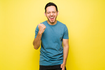 Canvas Print - Successful hispanic man cheering for his triumph