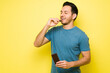 © AntonioDiaz - Hispanic man taking a bite out of chocolate