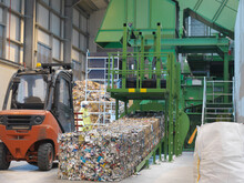 Worker Inspecting Baled Waste Aluminum Cans In Waste Recycling Plant.