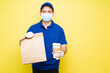 © AntonioDiaz - Delivery worker with a face mask delivering fast food