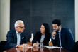 © Connect Images - Businessmen and woman having discussion at boardroom table