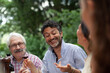 © Image Source - Mature man talking at outdoor meal