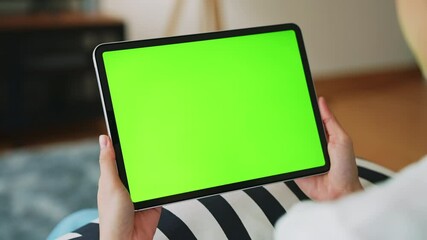 Wall Mural - Close up of woman holding in hands a digital tablet with green screen for internet online, chroma key screen for advertising.