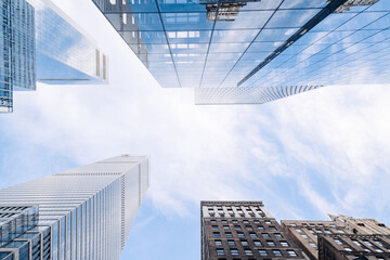 City skyscrapers bottom view against blue sky. Low wide angle shot, from ground. Modern business district concept, 3d render. Copy space