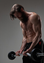  Caucasian athlete doing workout with barbell in gray background