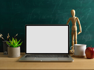 Wall Mural - Mock up laptop, stationery, decorations and apple on wooden desk with chalkboard wall background