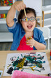 © Bangkok Click Studio - Asian girl with Down syndrome smiling and painting.