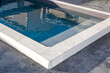 home blue swimming pool with stone coping with a waxed concrete terrace house