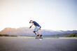 © Dewald - Skateboarder skateboarding on an open road doing freestyle tricks