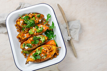 Stuffed sweet potato with spiced chickpea, dressing and herbs.