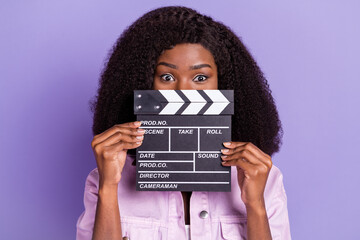 Canvas Print - Photo of young beautiful charming african lovely woman cover close mouth with movie clapper isolated on violet color background