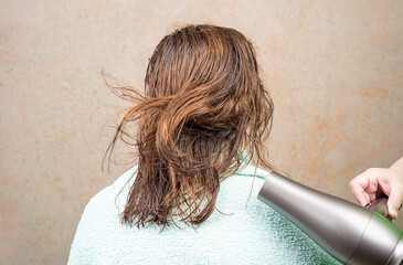 Women s hair flutters under the hot air from the hairdryer.