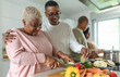 © Alessandro Biascioli - Happy African family having fun in modern kitchen preparing food recipe with fresh vegetables - Food and parents unity concept