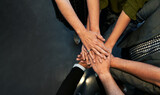 Fototapeta Mapy - High angle view of business team stacking hands