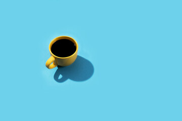 Yellow cup of coffee on a blue background.